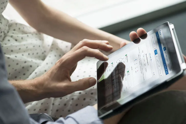 Two hands interacting with a digital tablet