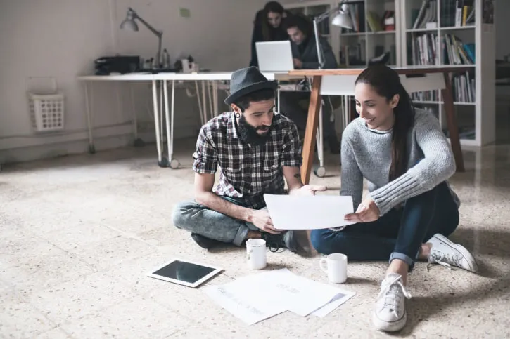 young couple sitting on the floor going over finances