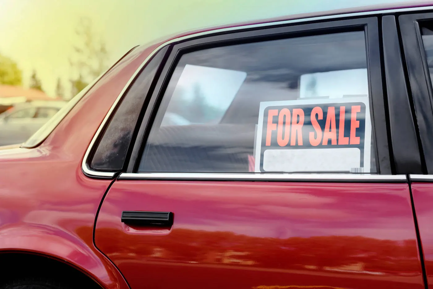 red used car with a for sale sign on it's window