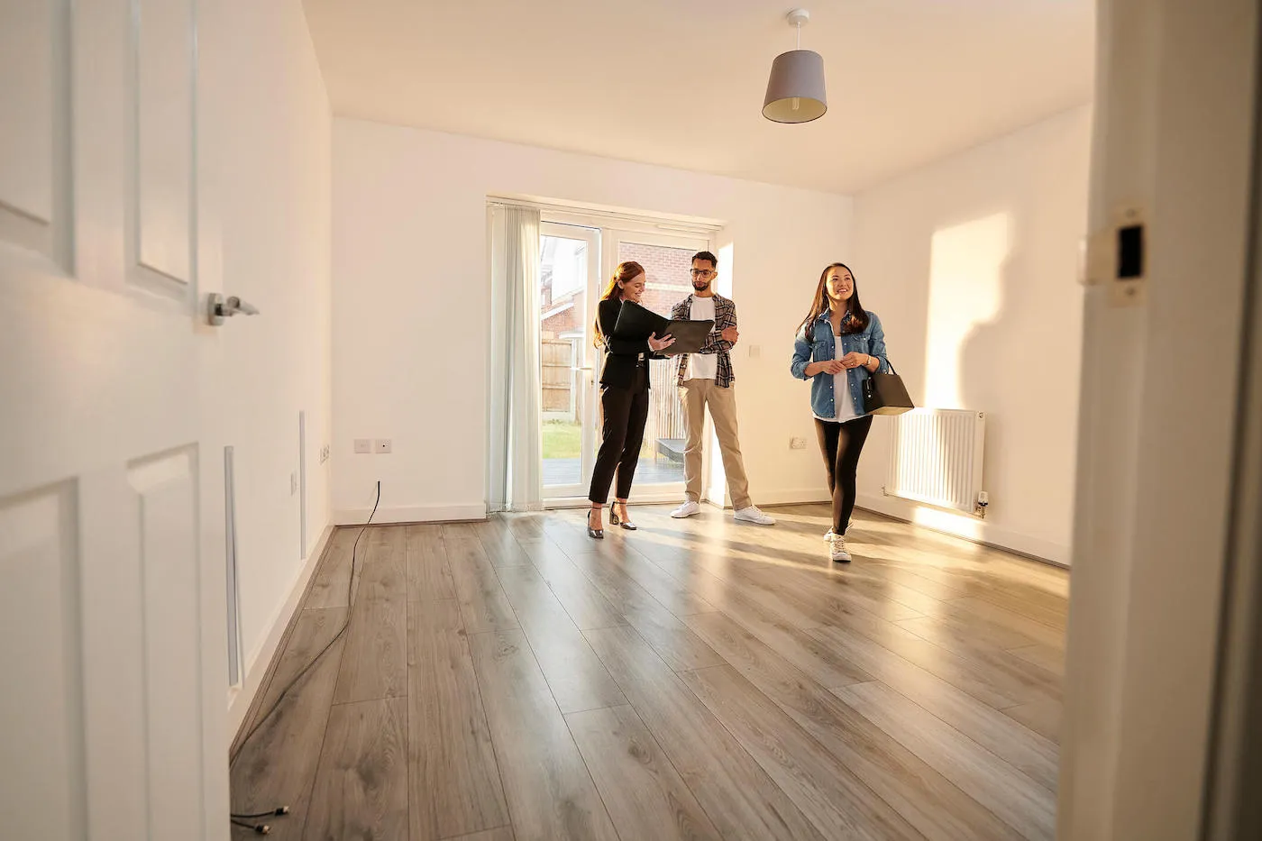 couple entering new empty house with real estate agent