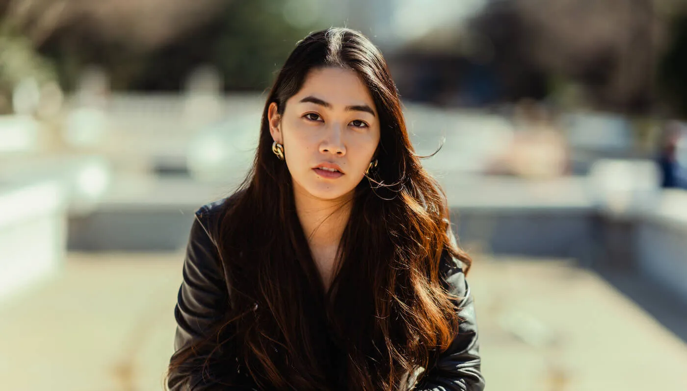 young woman with long brown hair dressed in a business suit looking serious