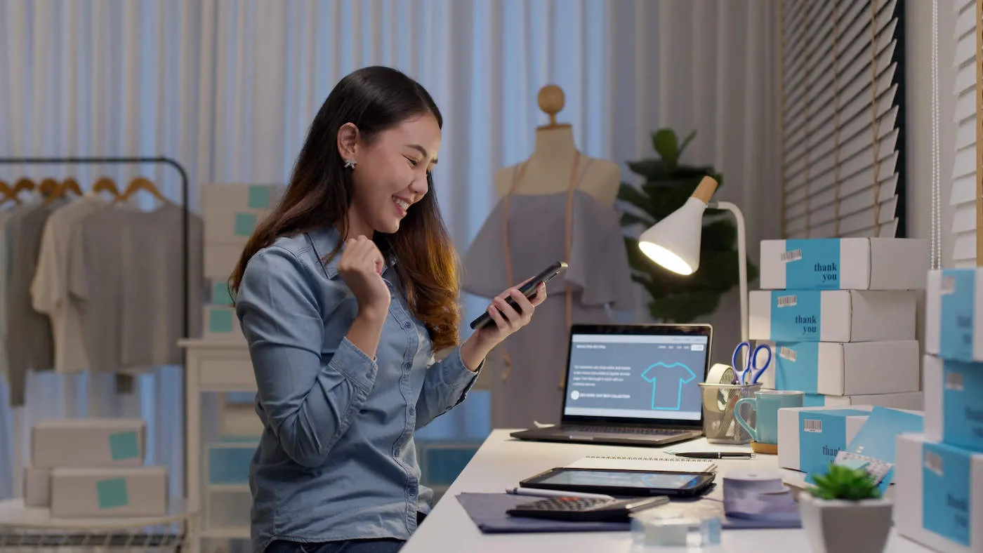 woman holding phone excited to see income increase