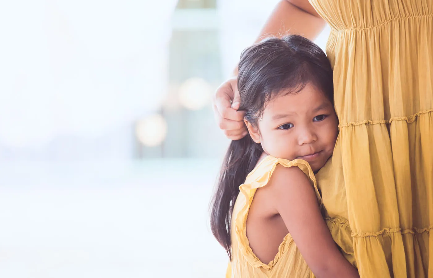 girl in yellow dress hugging leg