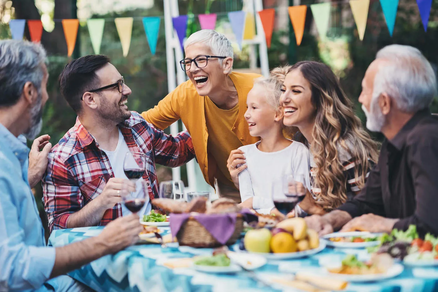 A family is laughing with each other while they eat food and celebrate.