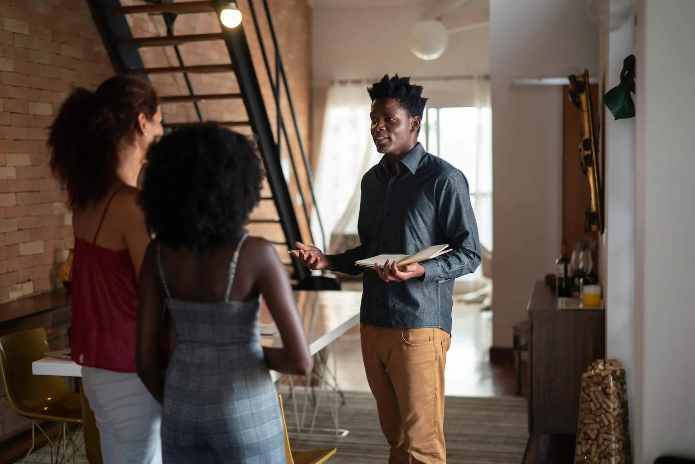 A landlord talks with two tenants inside an apartment.