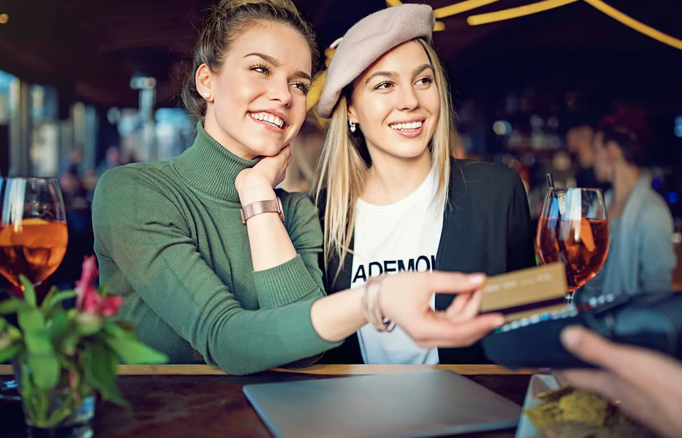 A woman paying for the restaurant tab with her credit card.