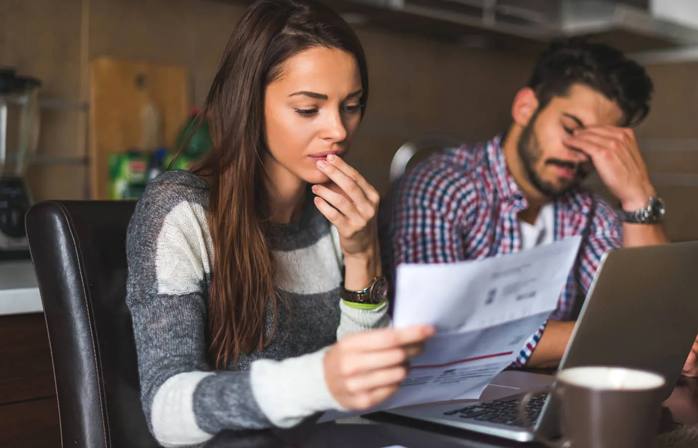 A man and a woman looking at financial documents together at a table.