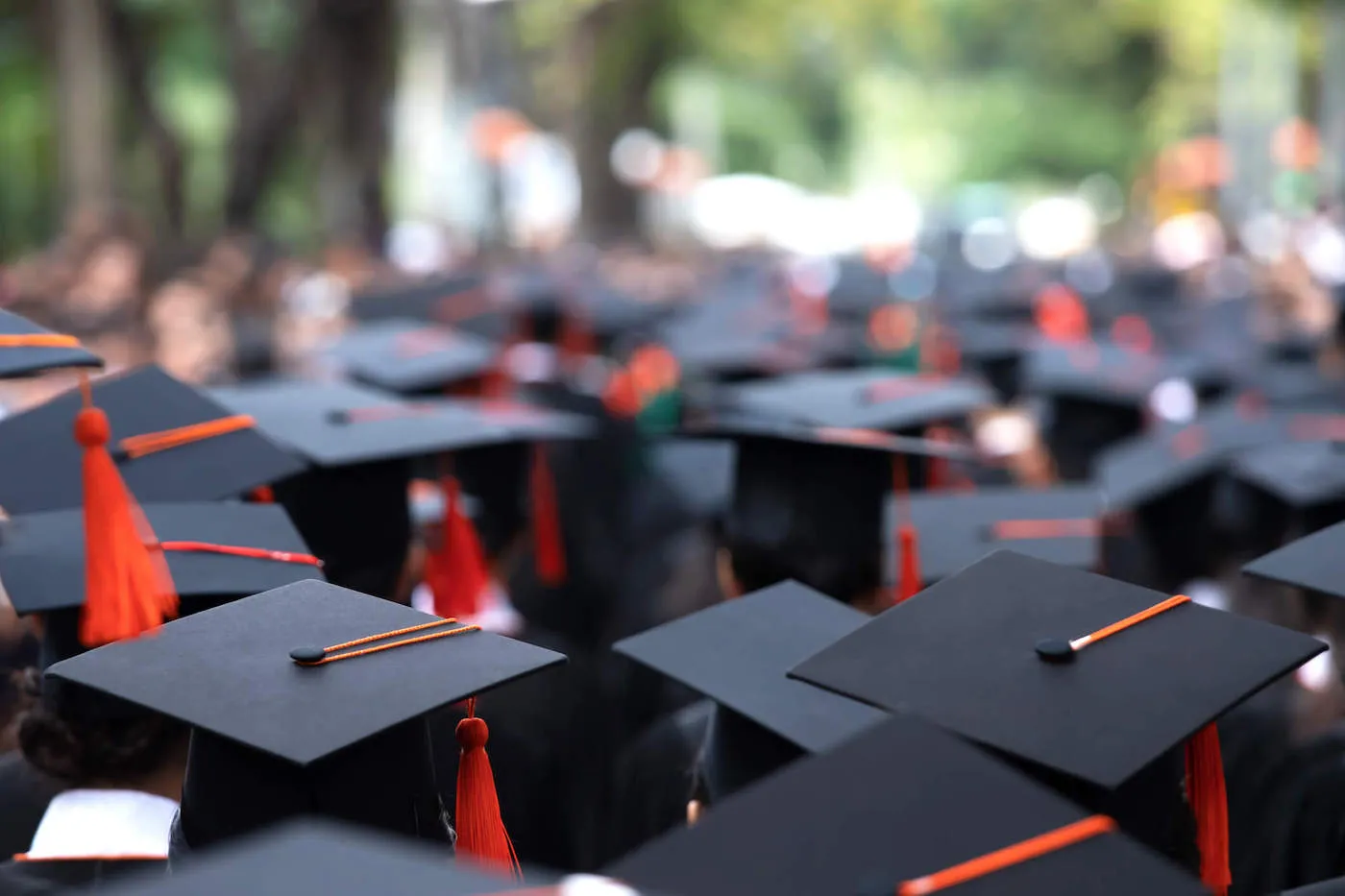 Graduation day for college students wearing their black graduation caps.