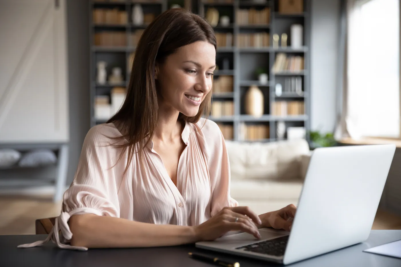 Happy young woman browsing internet on laptop