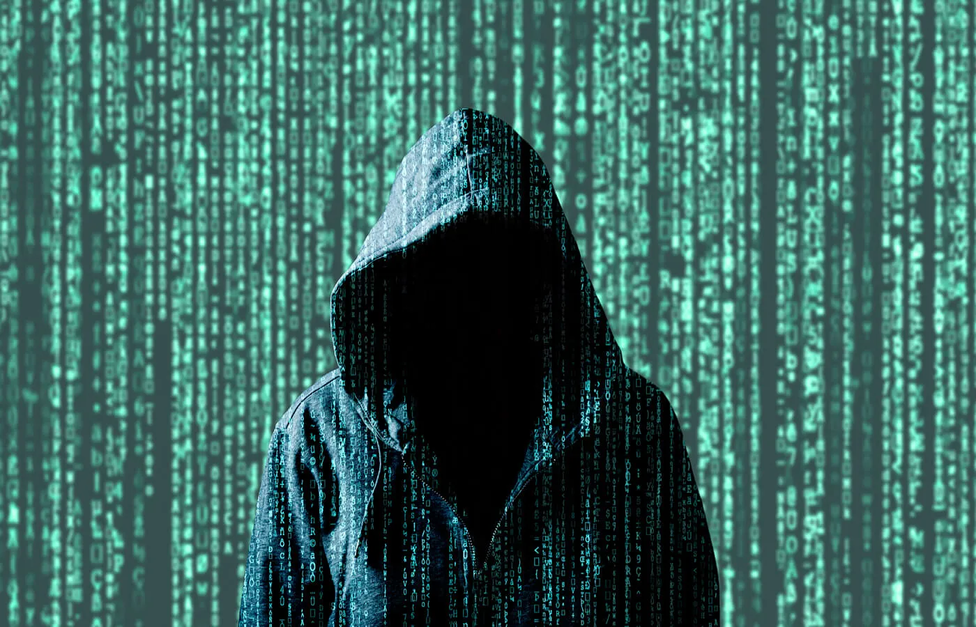 A dark hooded figure stands in front of a background of green pixelated numbers.