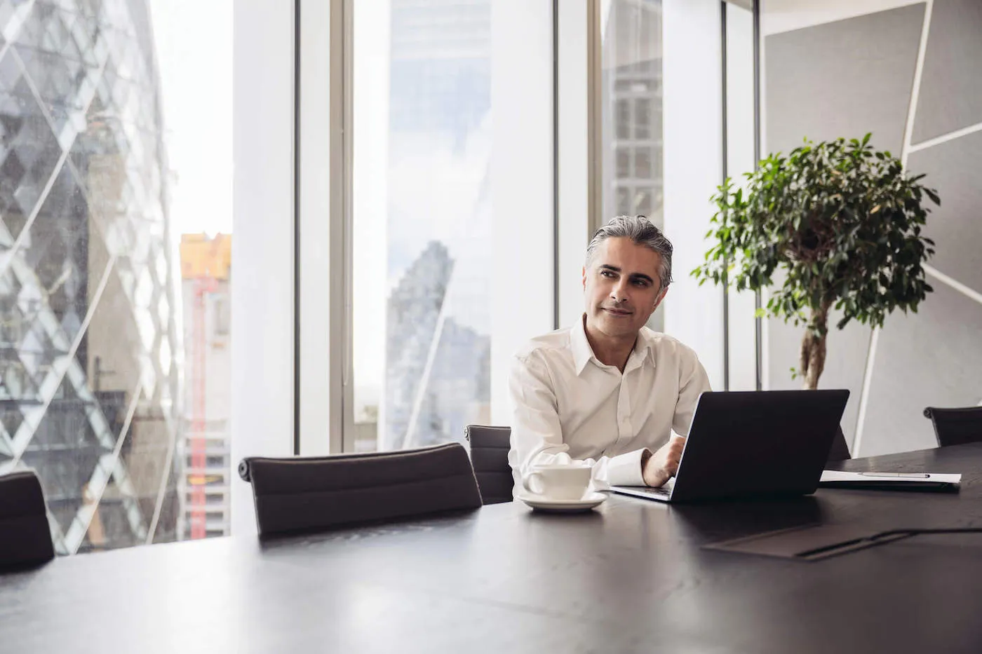 London executive using laptop in modern board room.