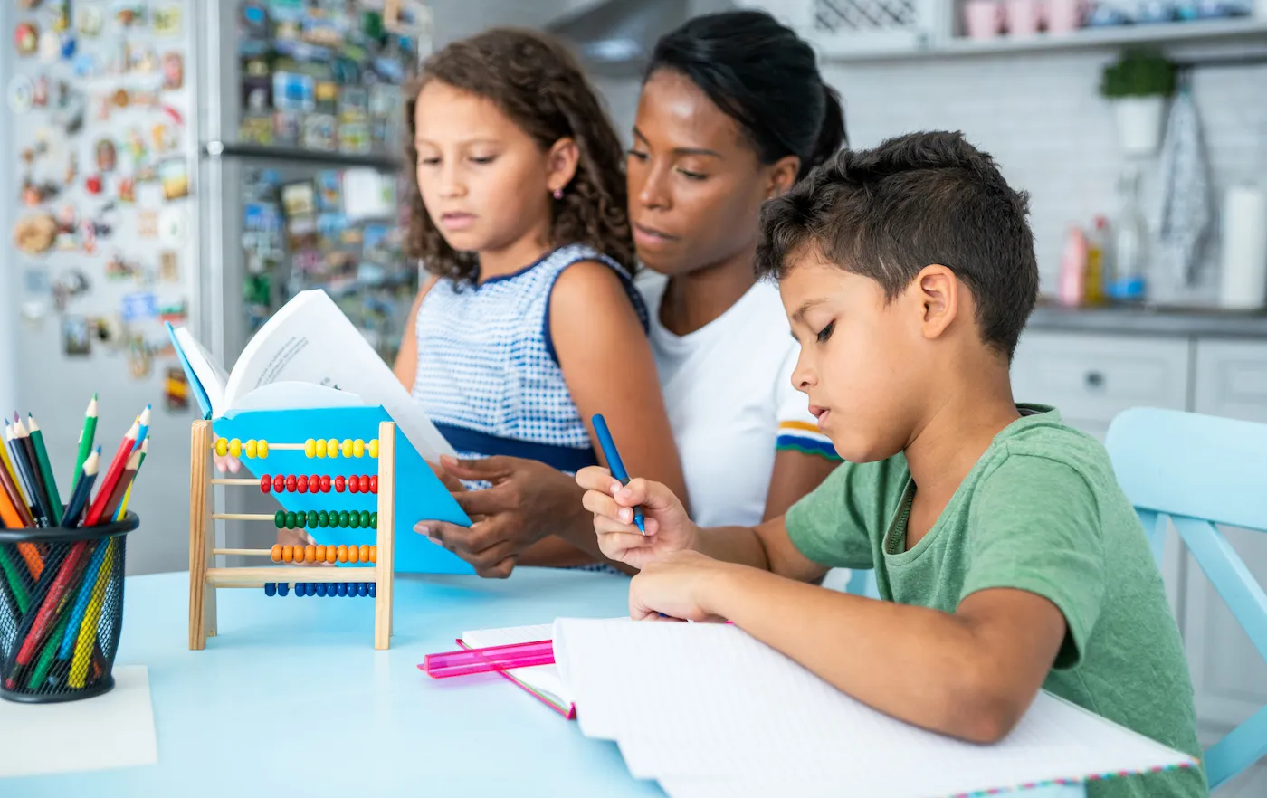 Mother helping her children with their homework