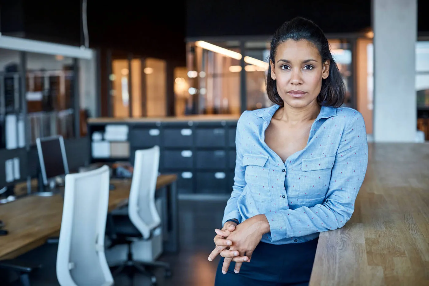 Portrait of confident young businesswoman leaning on counter.