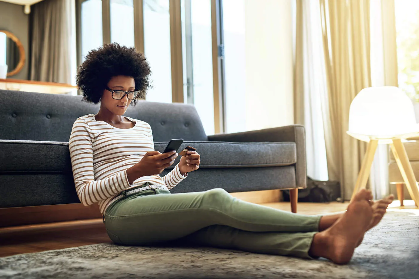 Shot of a focused young woman doing online banking with her phone.