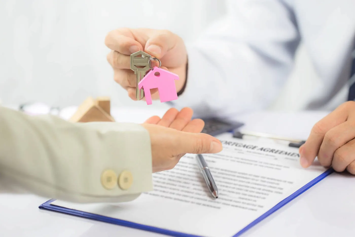 keys with a house keychain handed to recently refinanced home owner