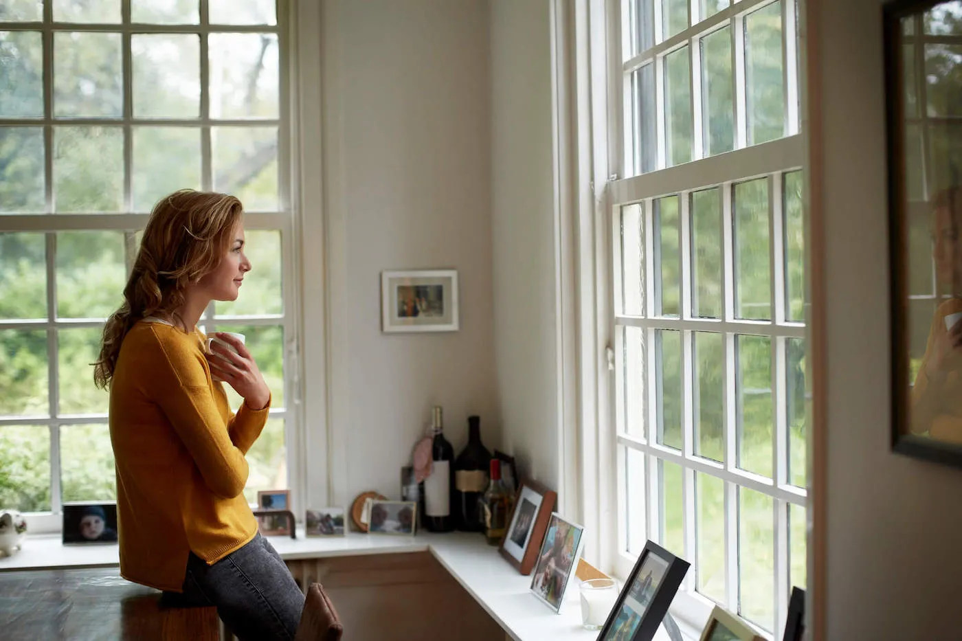 Thoughtful woman having coffee in cottage.