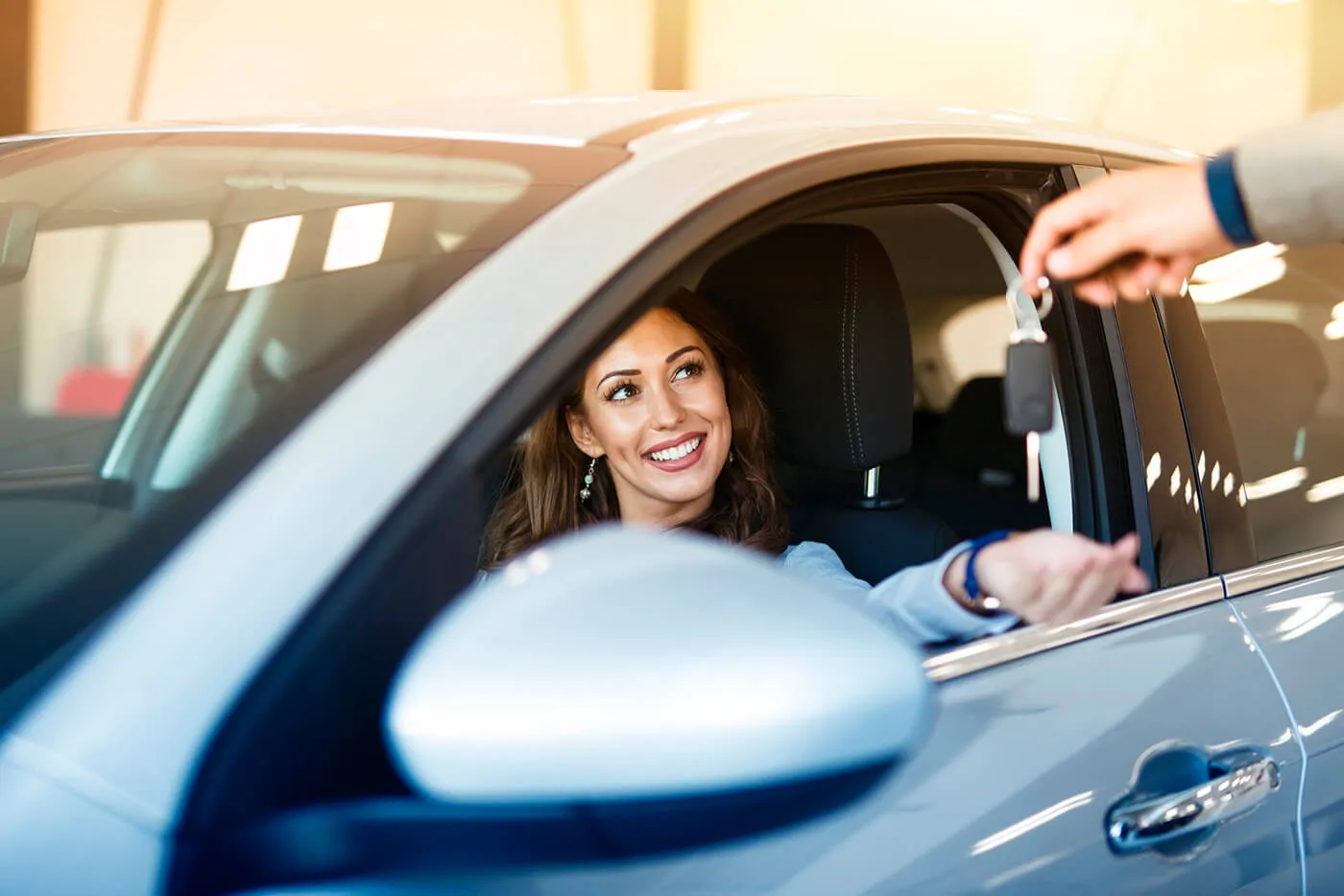 woman in car reaching out for keys through the window