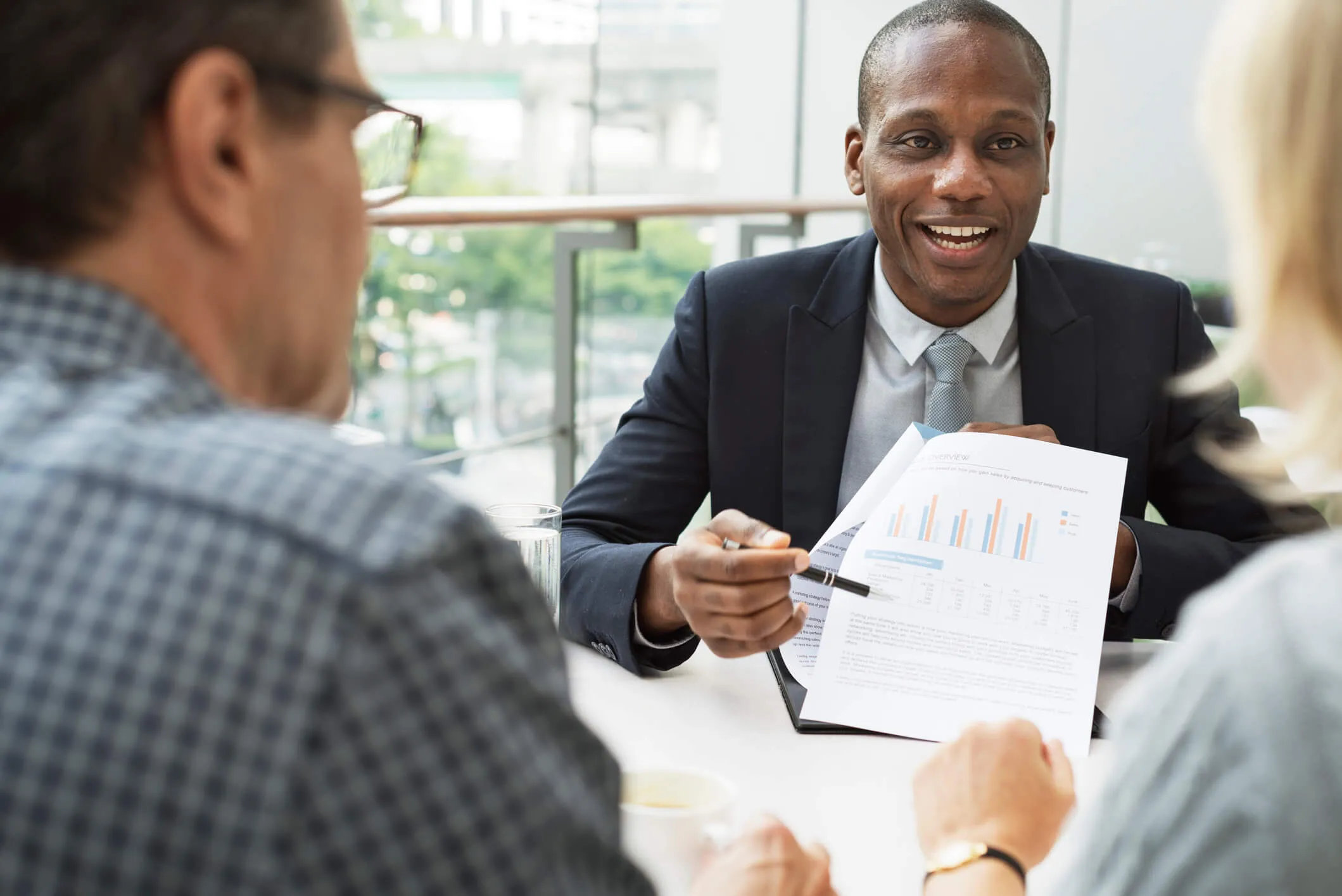 african american man in business suit explaining index funds to man and woman couple