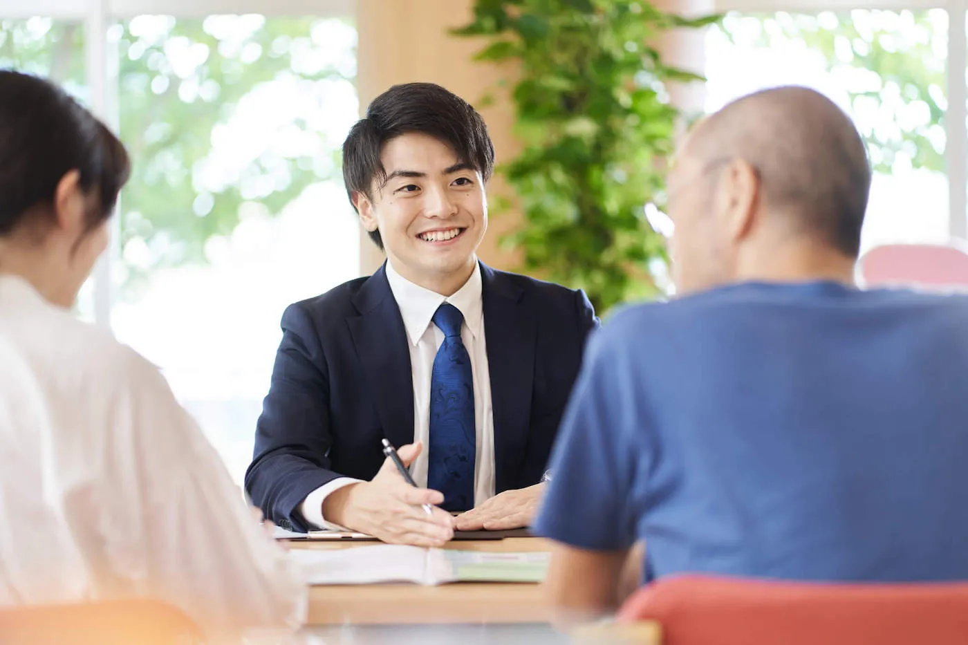 man in suit explaining no fault insurance to man and woman couple