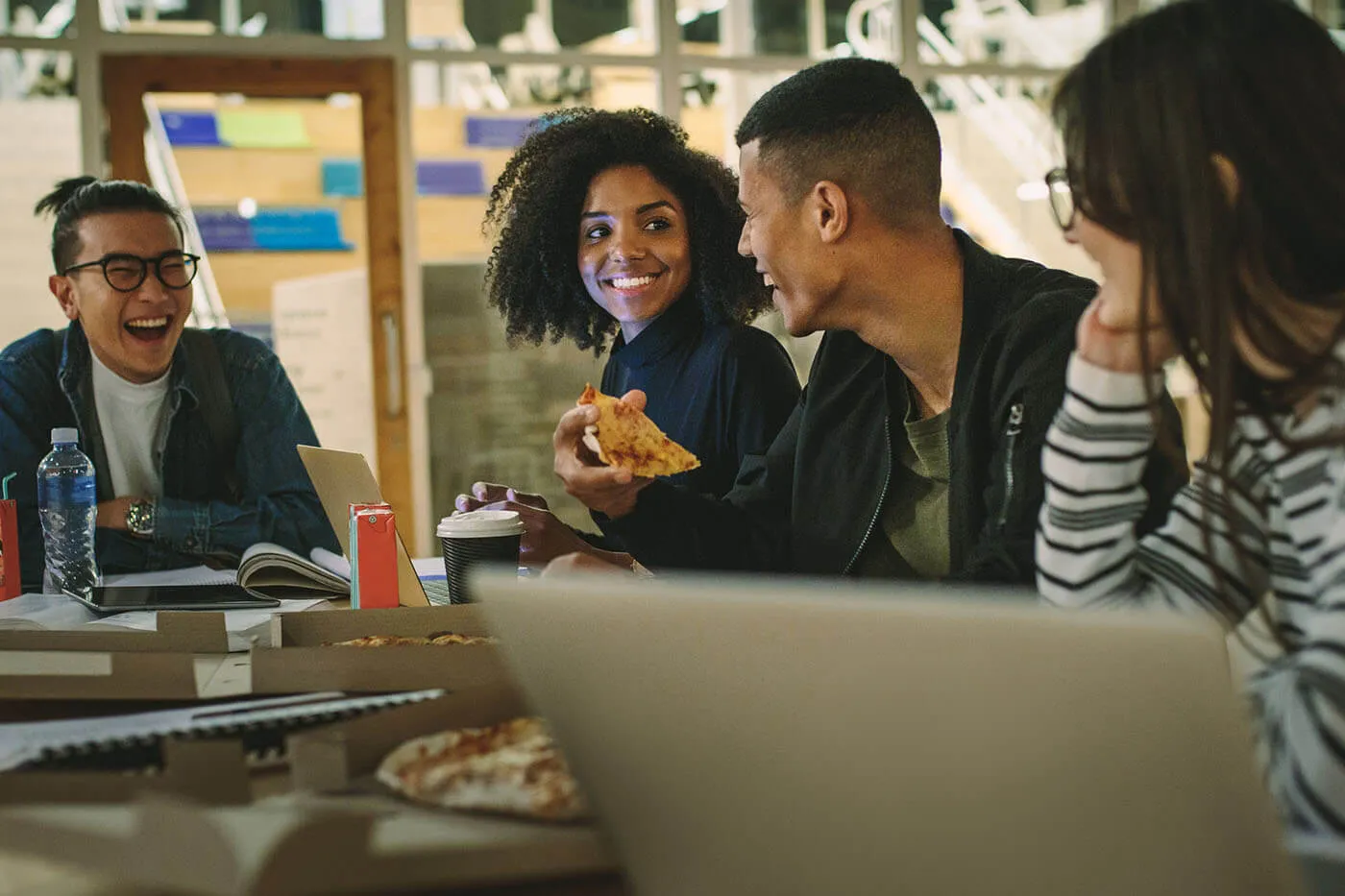 College students hanging out in a group around a table.