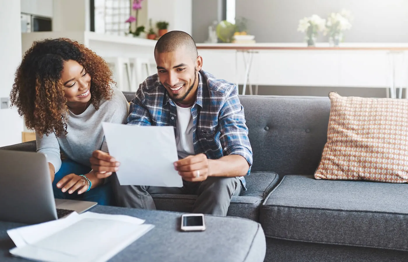 Couple sitting on the couch reviewing paperwork for a secured loan