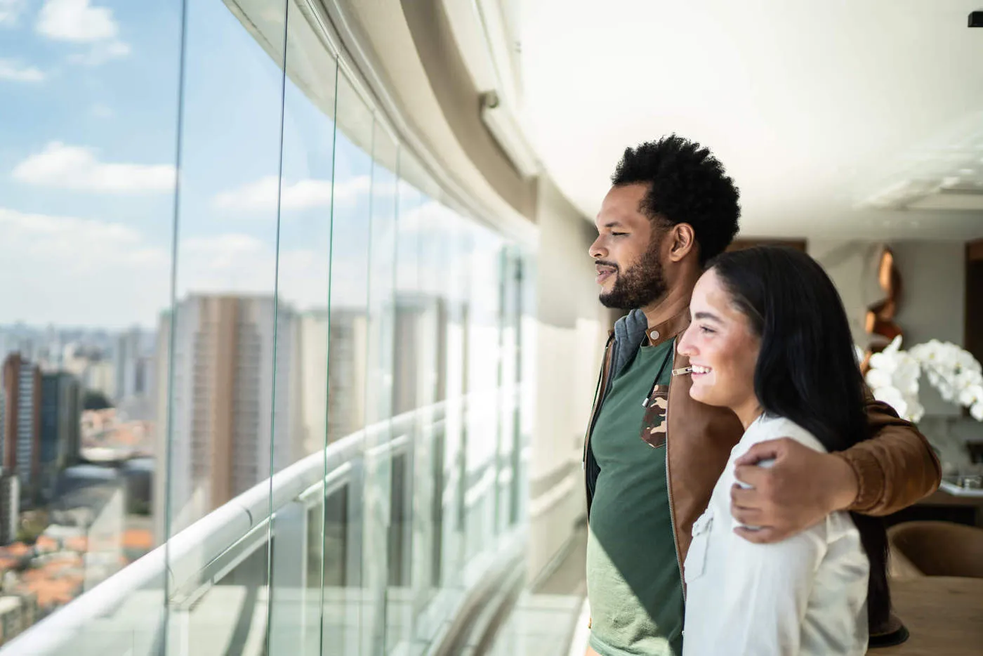 young couple looking outside of window