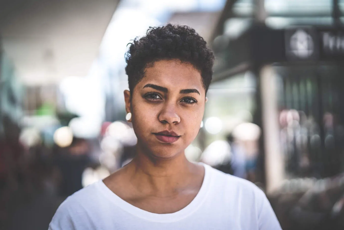 woman in white t-shirt looking serious and inquisitive