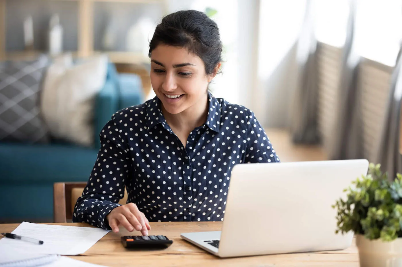 Young Indian woman paying bills on laptop online.