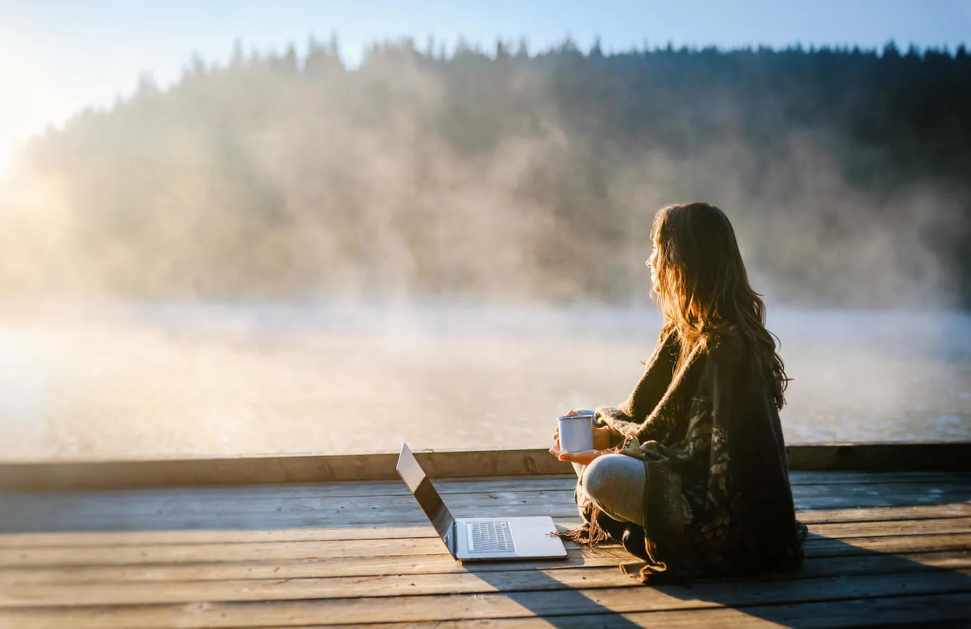 Young woman working on laptop in the nature.