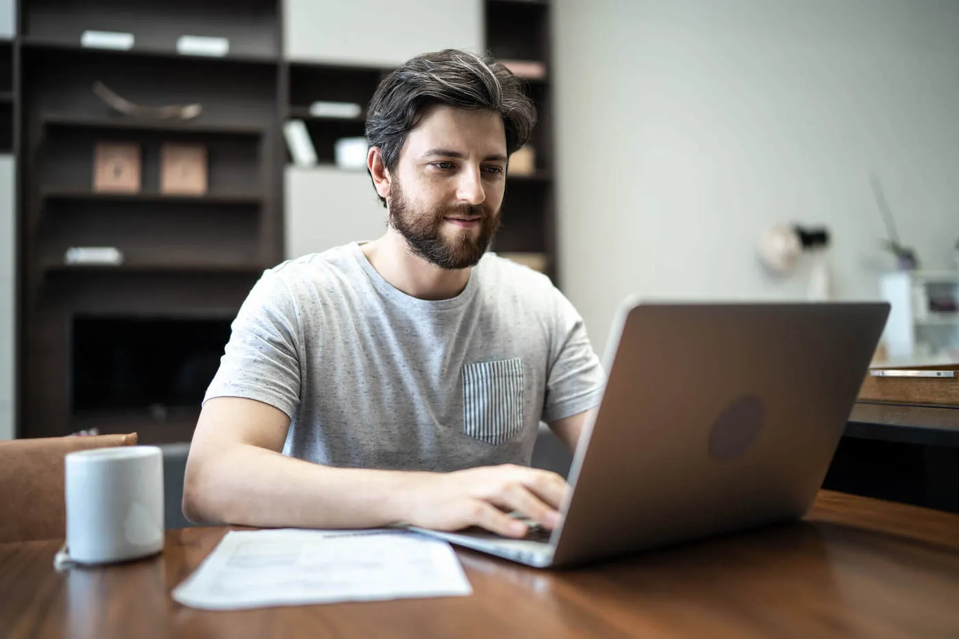 Adult man using laptop working from home.