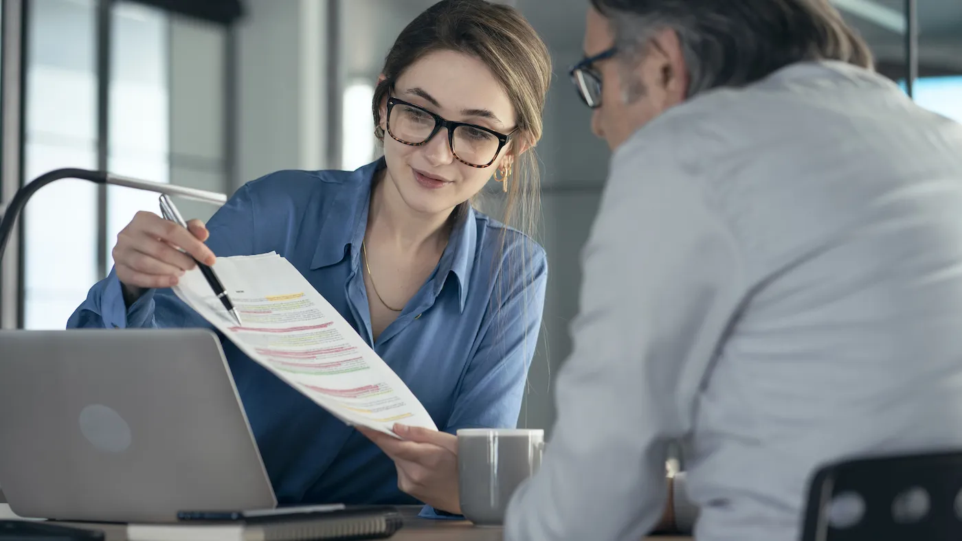 Bank employee helping customer with paperwork.