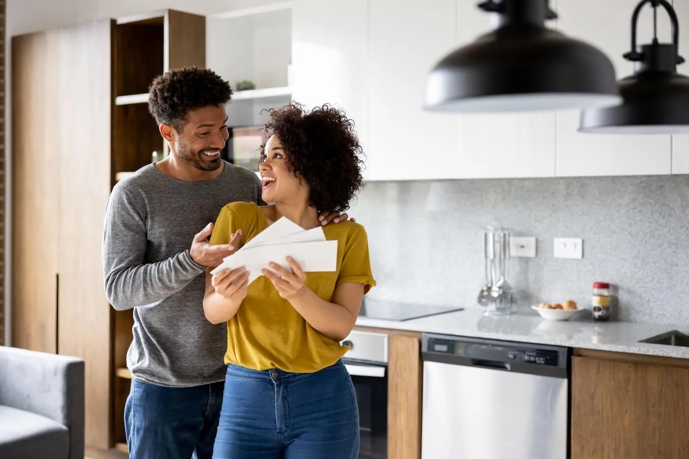 Happy couple reviewing their mail in the kitchen