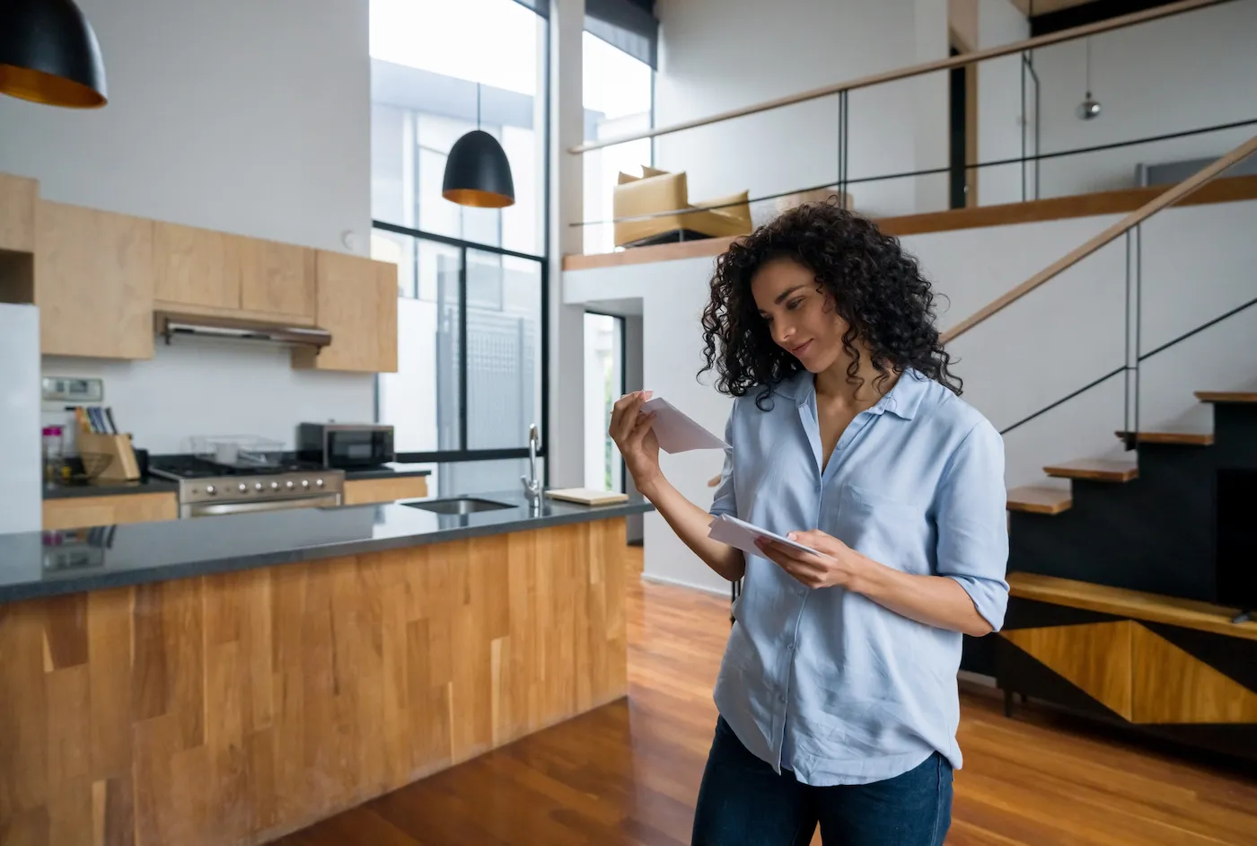 Woman checking bills in the mail and smiling