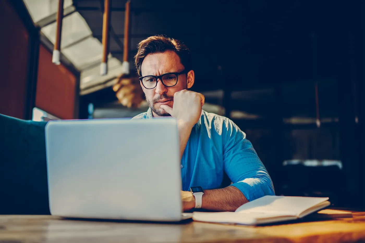 Concerned business owner with bad credit frowning at his laptop.