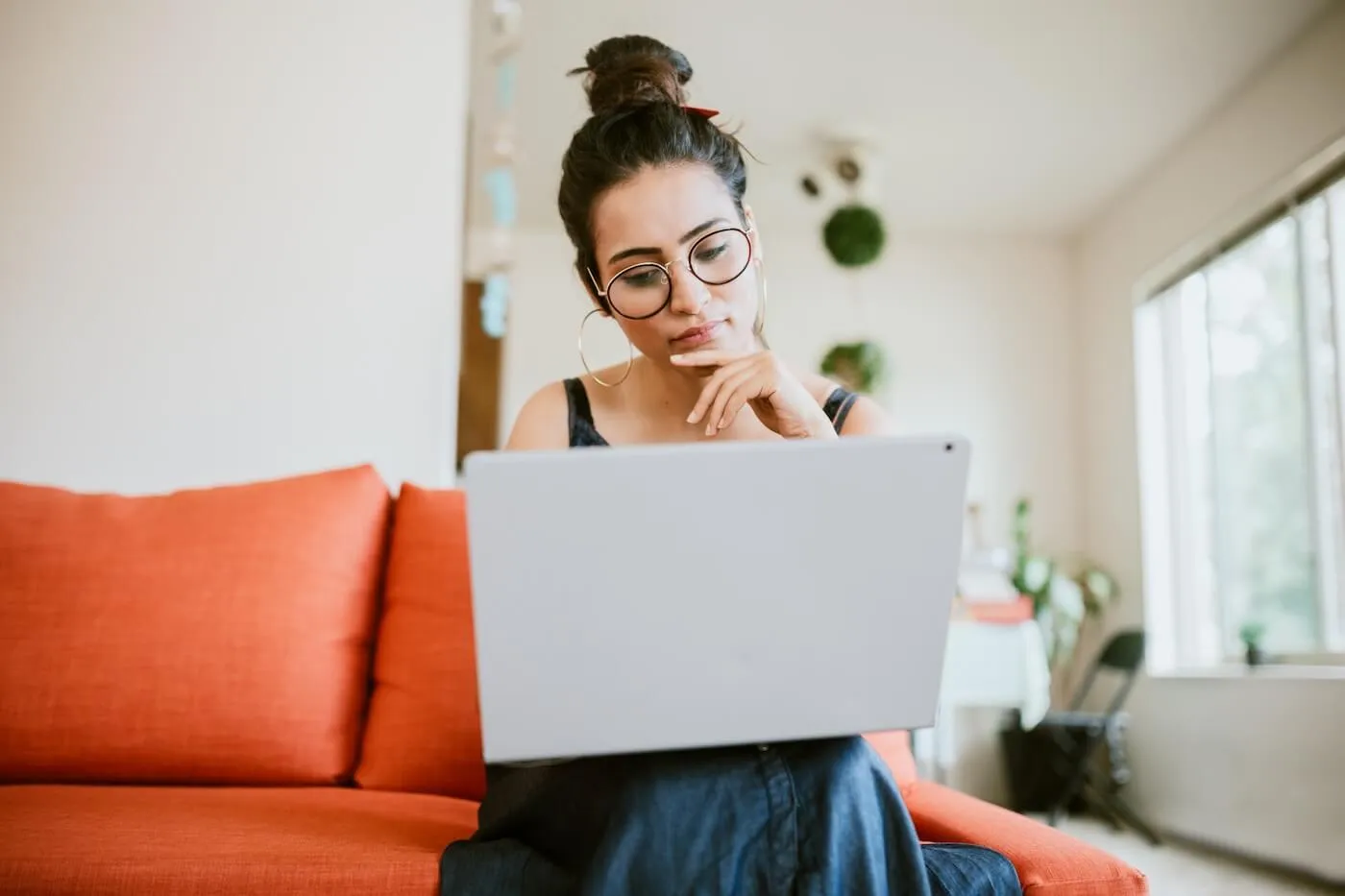 Focused woman with a laptop sitting on a couch