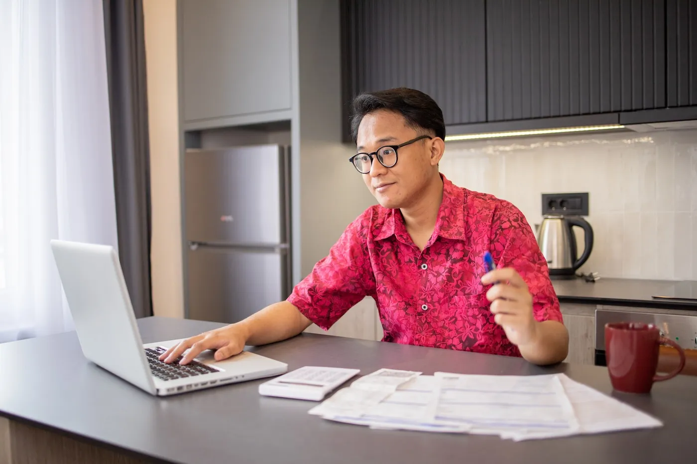 Man comparing life insurance rates at home on his laptop.