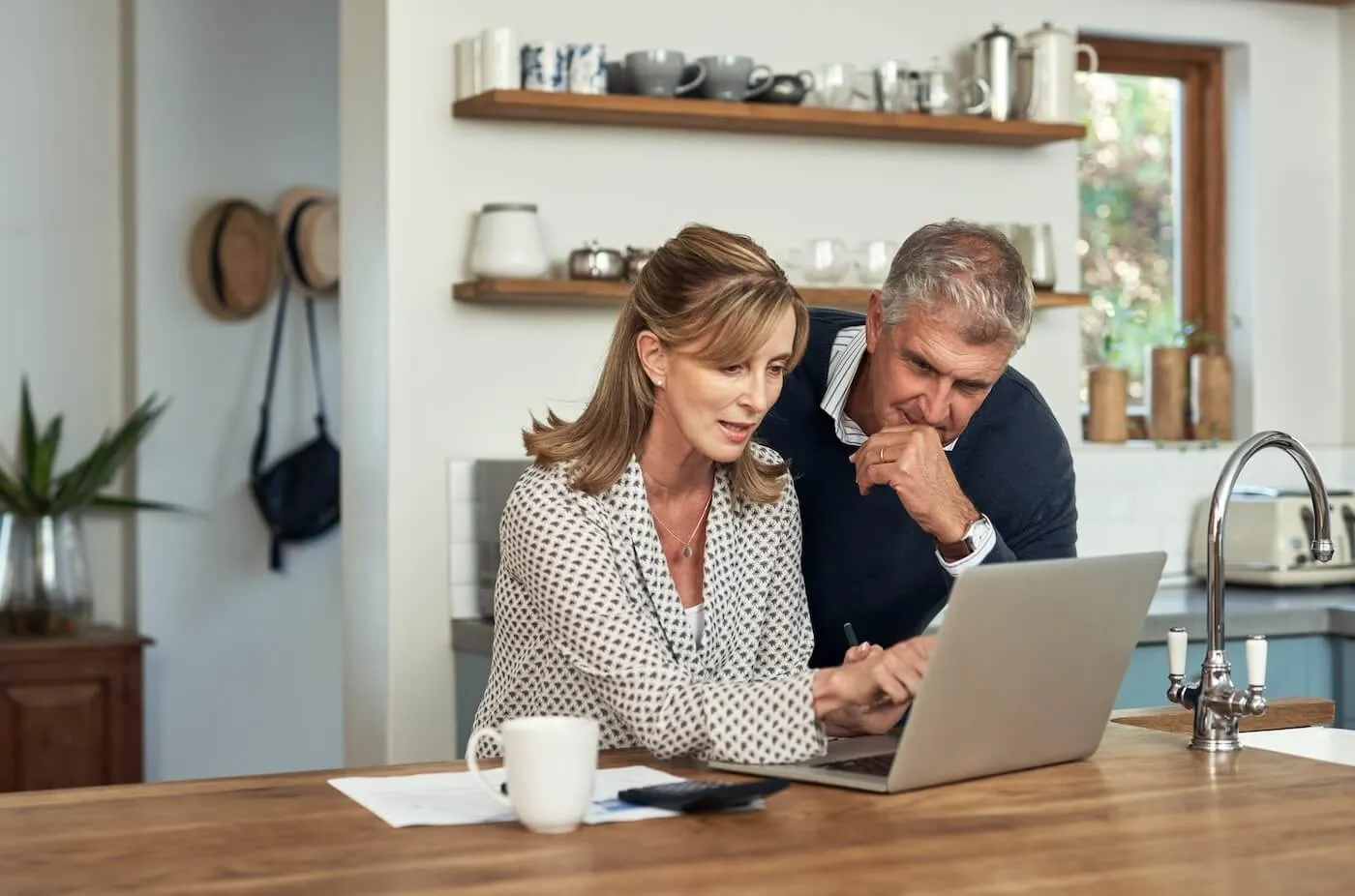 Mature woman showing something on the laptop to her partner