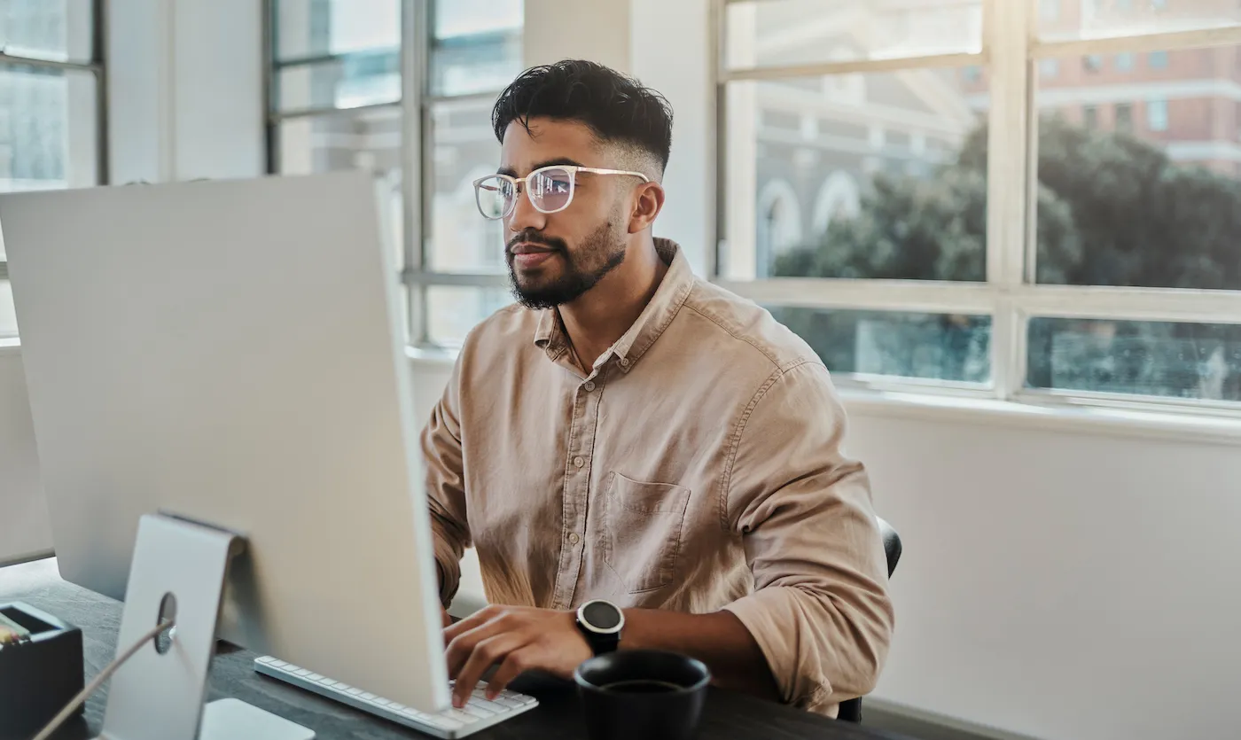 A man working on a computer in office researching how to refinancing a HELOC.