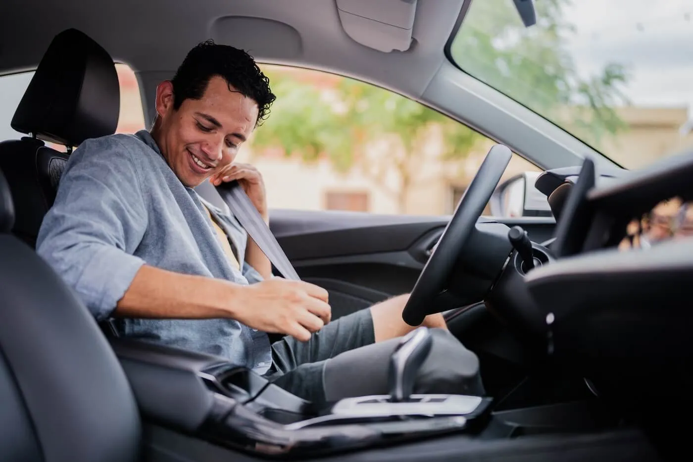 Smiling male driver buckling up his seatbelt