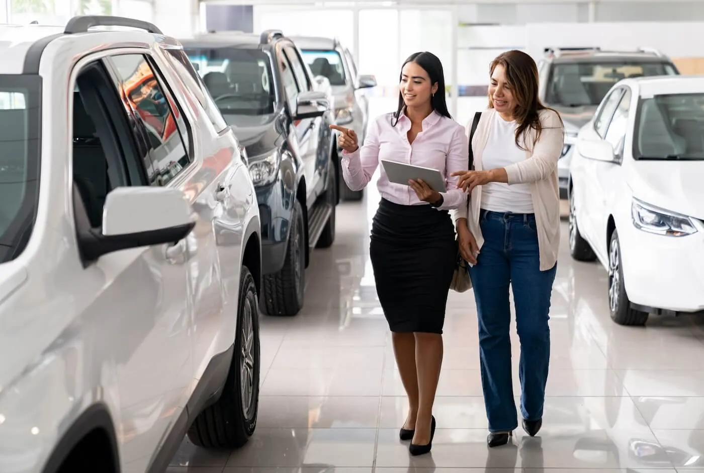 Woman choosing a new car with the help of a female dealership agent