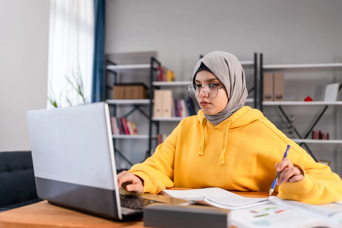 College student looking up student loan rates on her laptop.