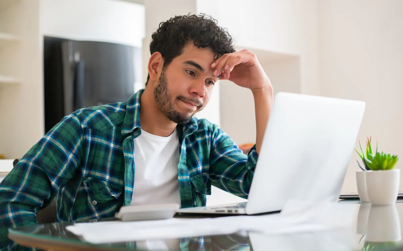 Concerned man checking his debt report on a laptop