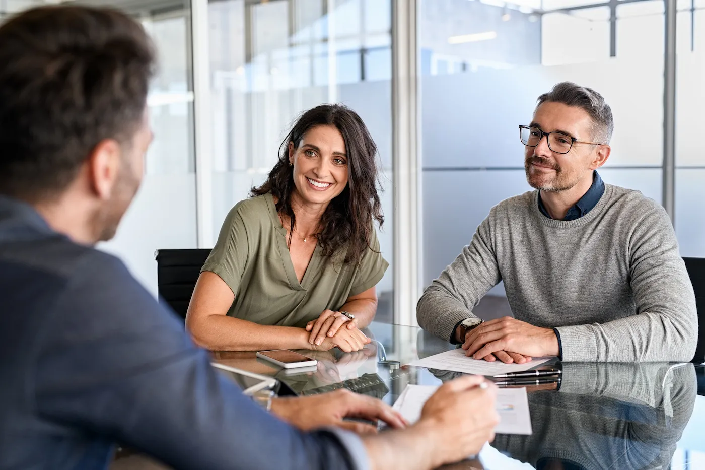 Smiling mature couple meeting with bank manager, considering switching banks