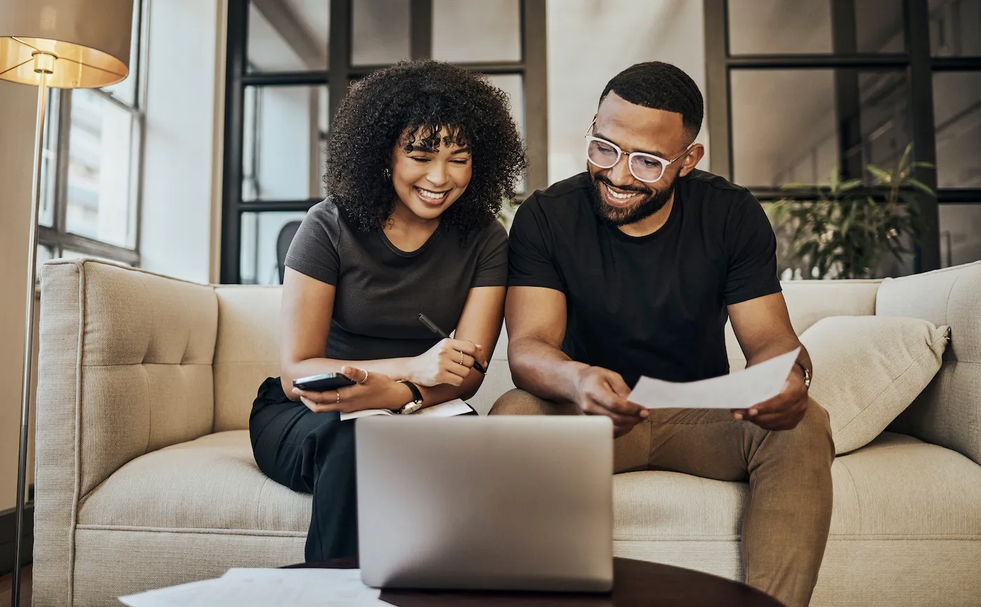 Couple sitting on the couch going through fnances to get a personal loan