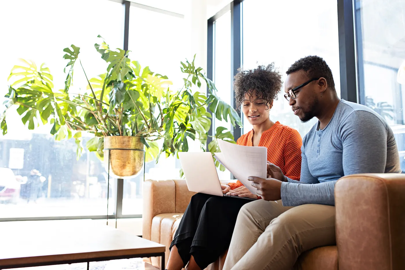 Couple sitting on couch reviewing their finances together.