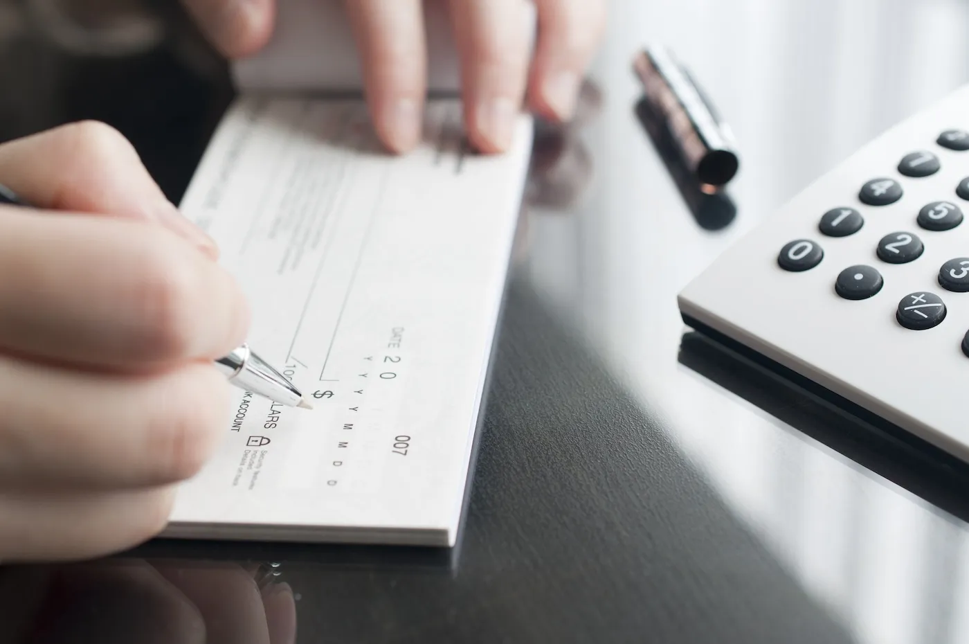 A woman writing a check at office