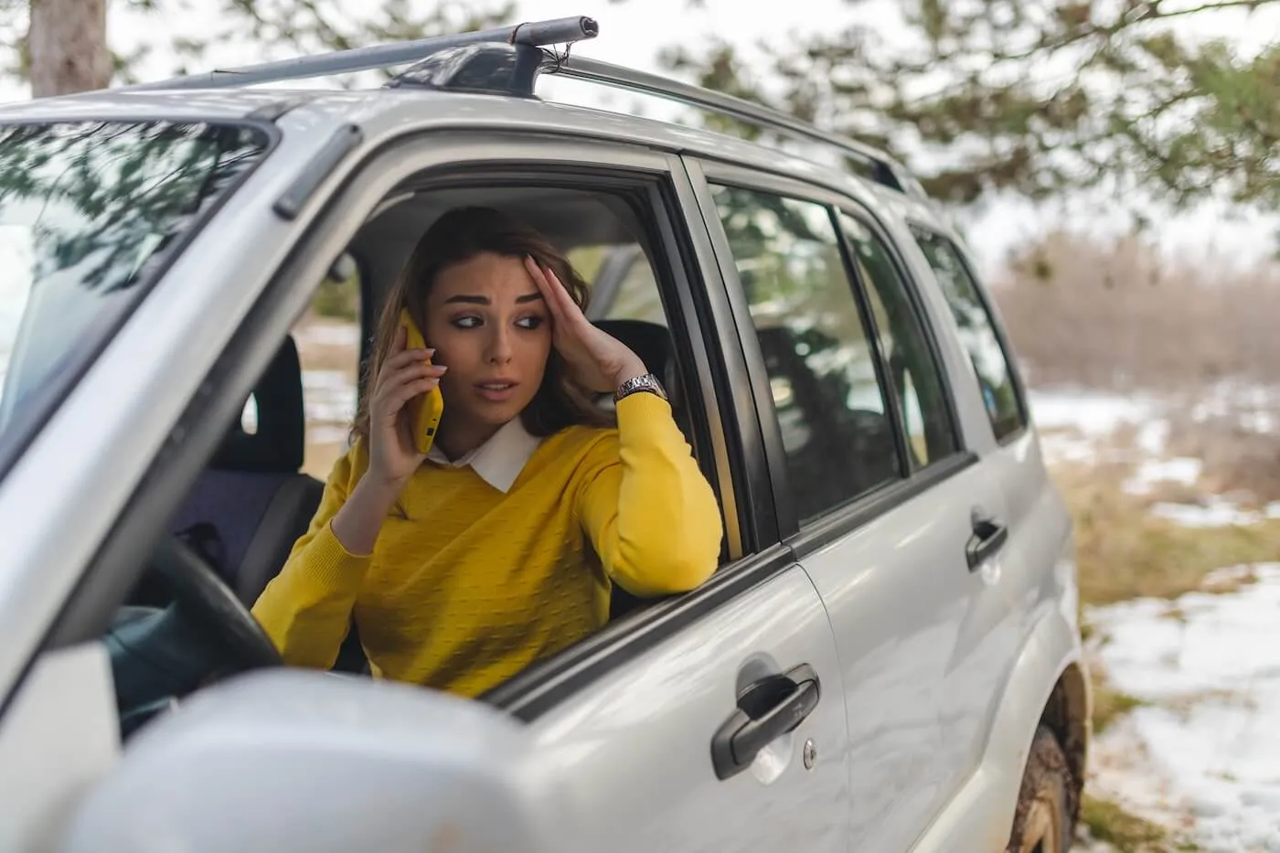 Upset woman is making a phone call from the parked car