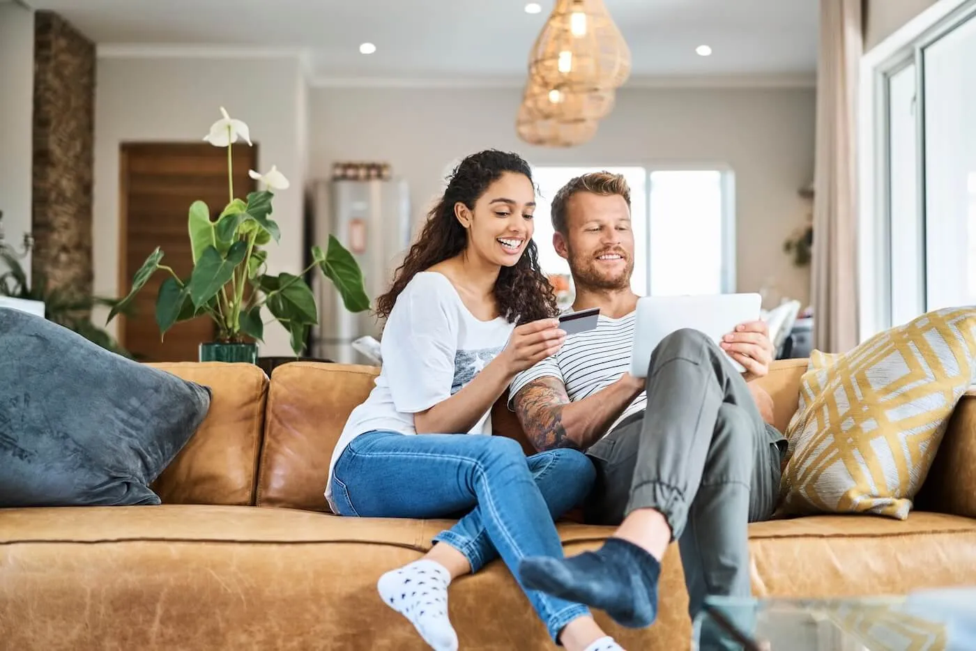 Happy couple activating a new credit card via tablet