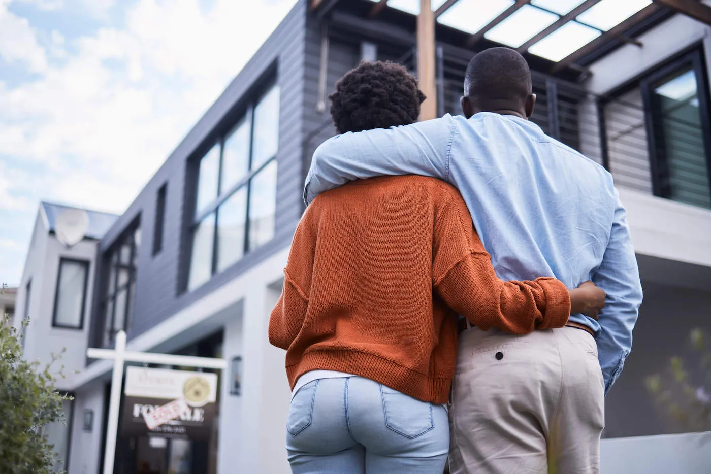 Embracing man and woman couple looking at a newly purchased home.