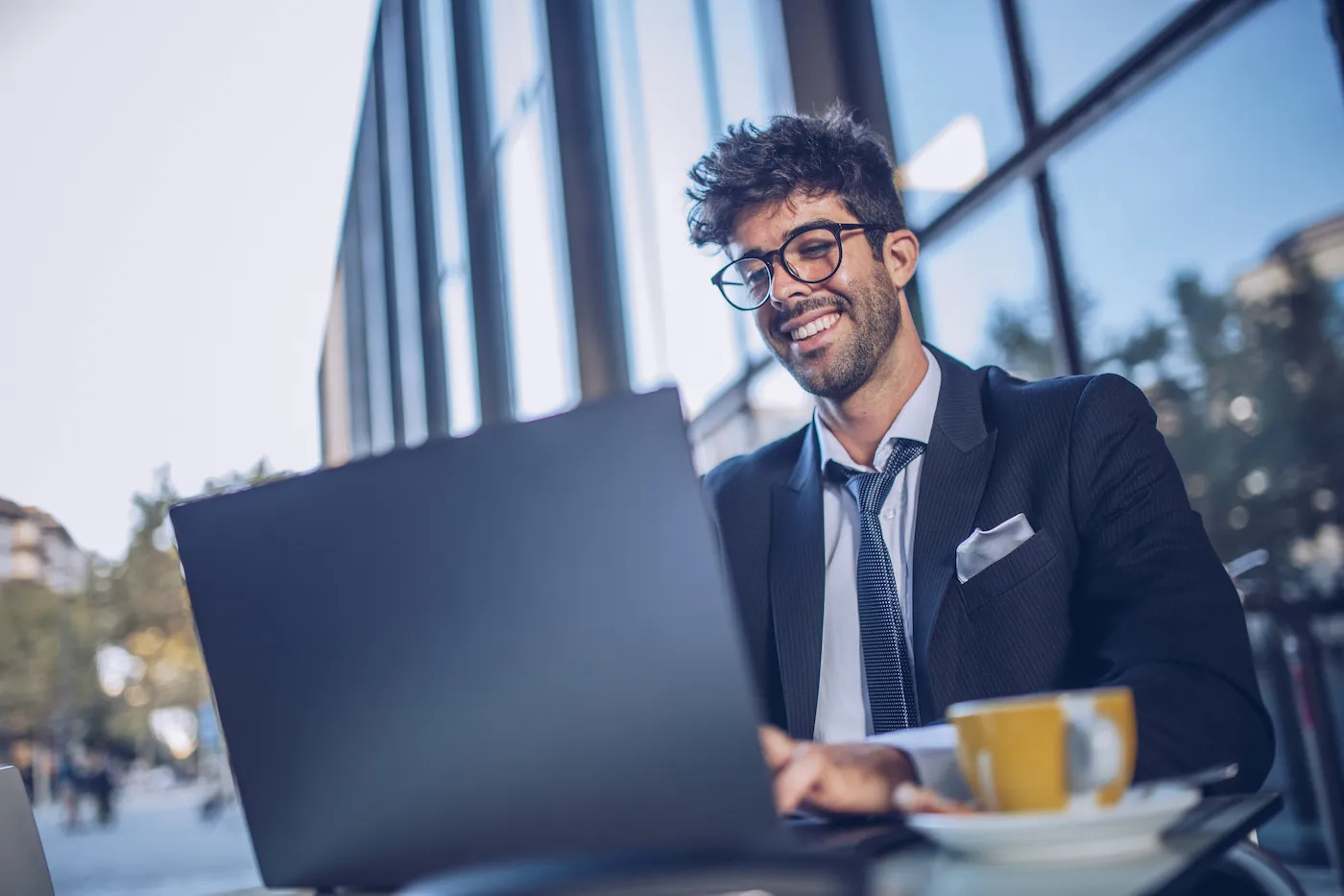 One man, young businessman sitting in cafe, using laptop.